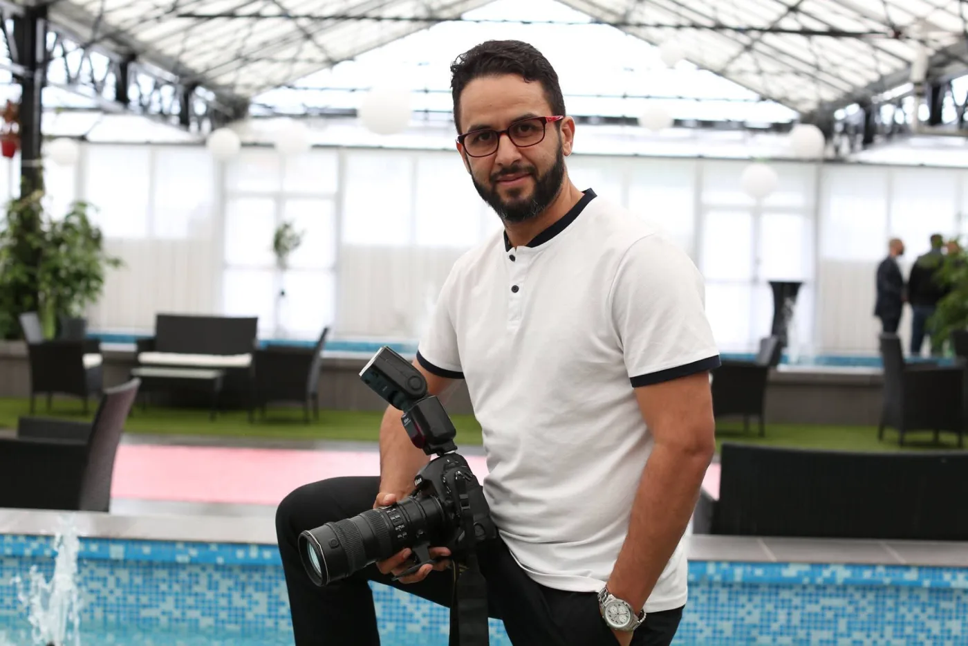 Rachid Douyeb tenant un boîtier photo équipé d'un flash