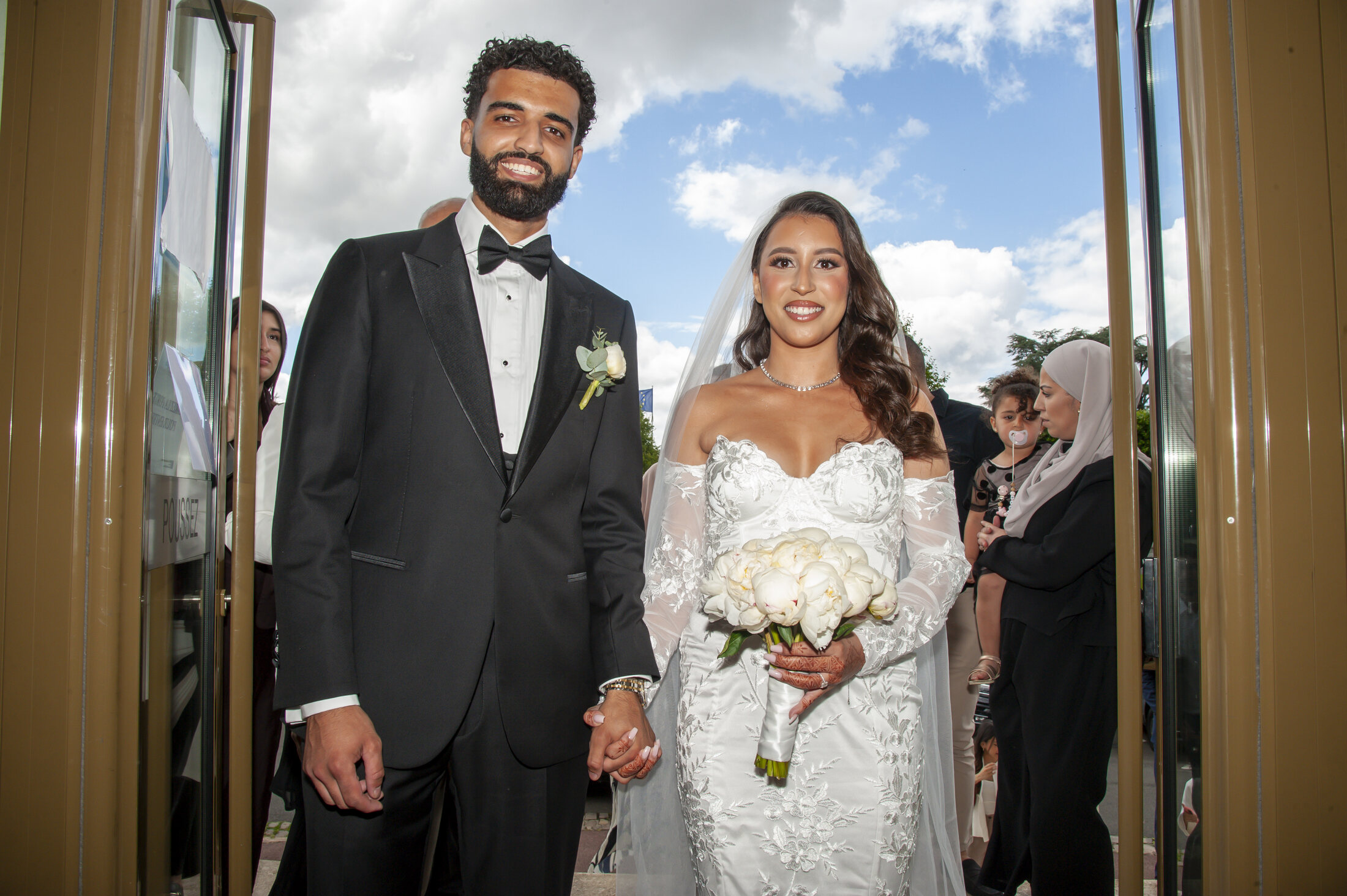 Couple de mariés sortant de cérémonie, photographié dans un style reportage