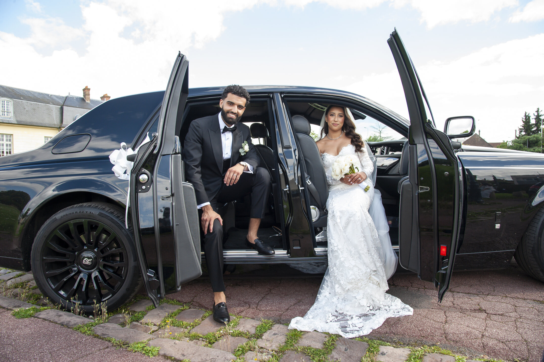 Portrait des mariés près d'une voiture de collection