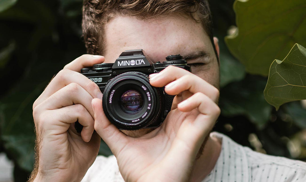 Photographe tenant un appareil photo argentique pour capturer un instant de la journée